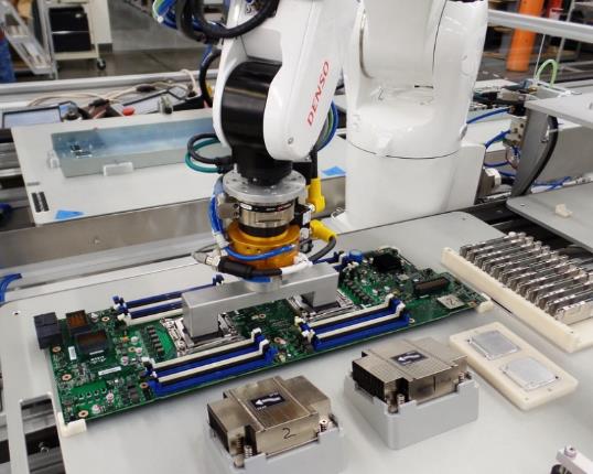 Six axis robot picks motherboard from parts carrier